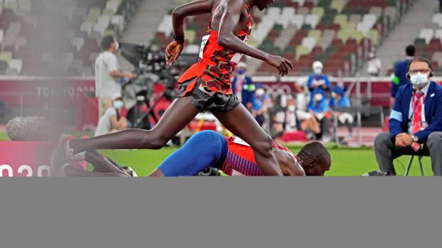 Paul Chelimo leans at the finish line to win bronze in the men's 5,000 meters at the Tokyo Olympics.